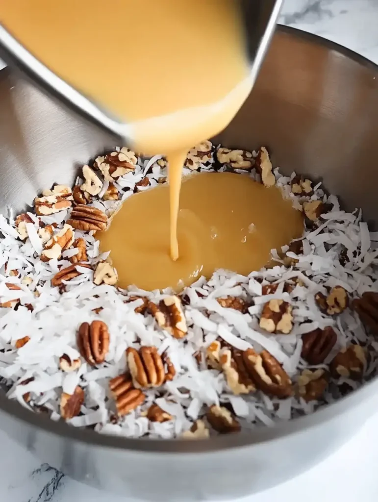 Pouring the coconut-pecan frosting mixture into a bowl with coconut and pecans.