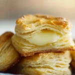 Warm, buttery homemade biscuit with flaky layers, showcasing a golden crust and melting butter.